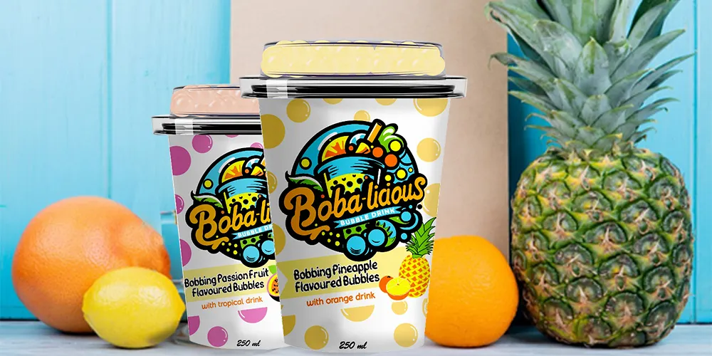 Bright and vibrant BobaLicious flavored bubble drinks on a wooden table, surrounded by fresh citrus fruits and pineapple, enhance the tropical theme.